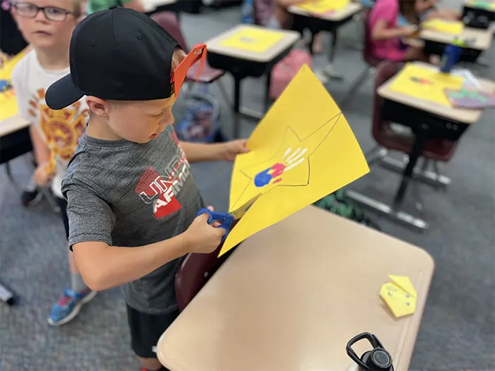 kid cutting star paper